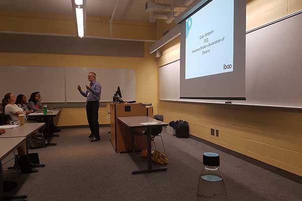 Man addressing a class full of students