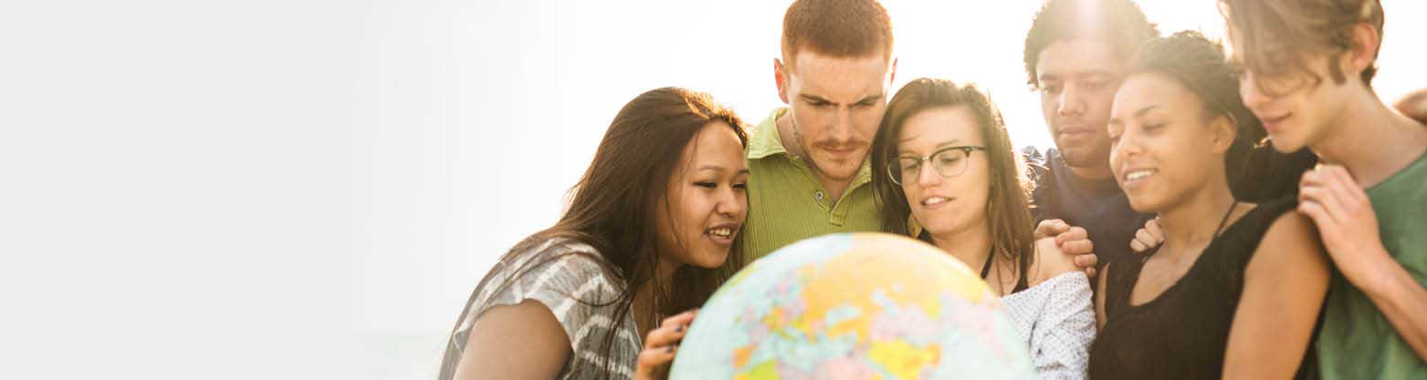 group of students looking at a globe