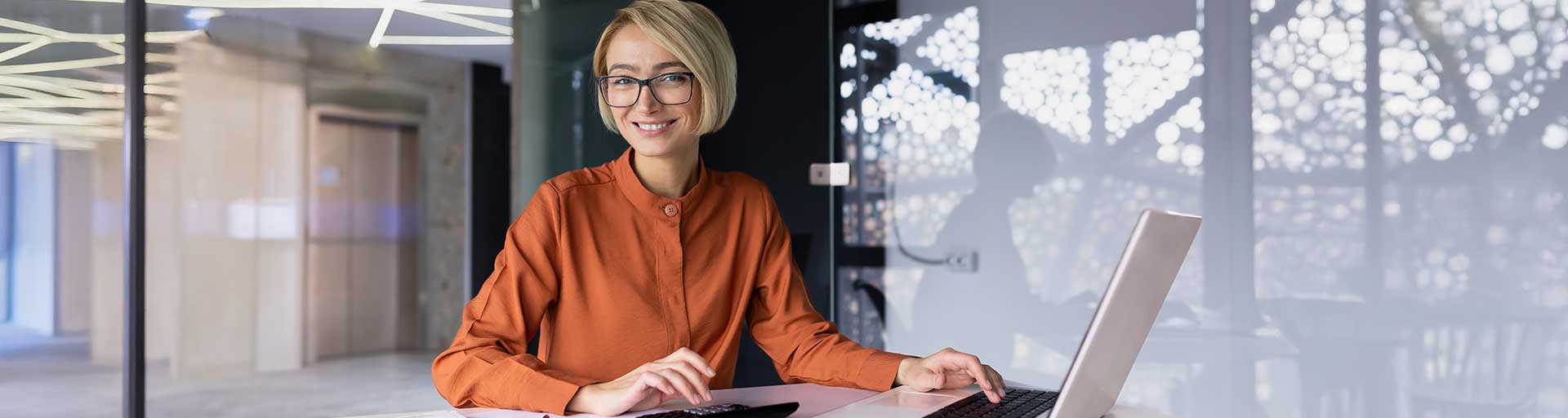 Person smiling at table with laptop