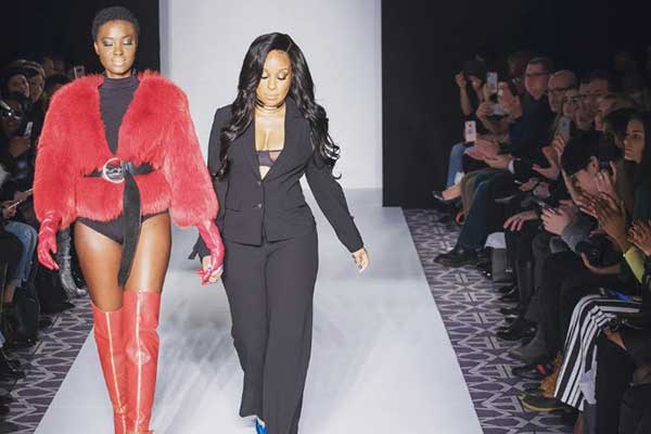 Taneish Leslie walking down the runway with a model