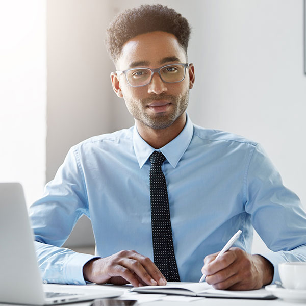 person sitting at desk writing in notebook