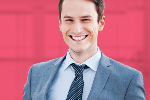 Smiling person in suit on a pink background