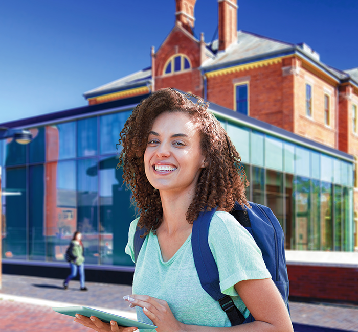 Woman smiling in campus holding an ipad