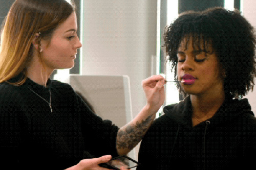 Person applying makeup on a model