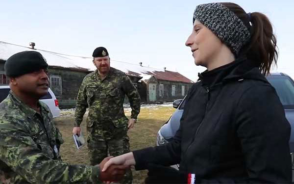 woman shaking hands with soldiers