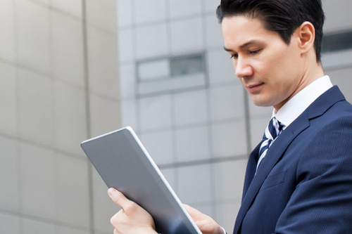 Person in suit looking at tablet