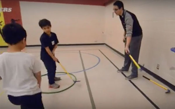 students teaching kids how to golf