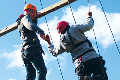 People climbing ropes in safety gear
