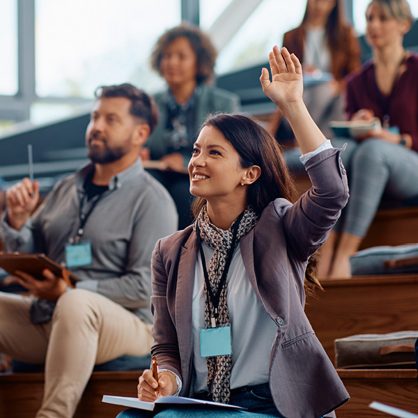 person sitting on bleachers raising hand