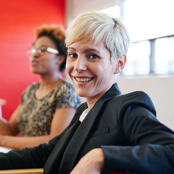 Person smiling sitting on a chair in meeting