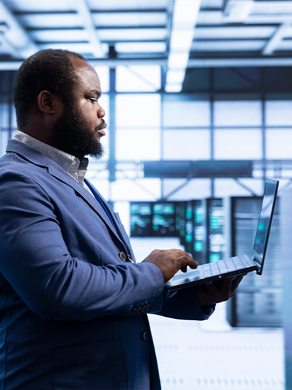 Person using laptop in server room