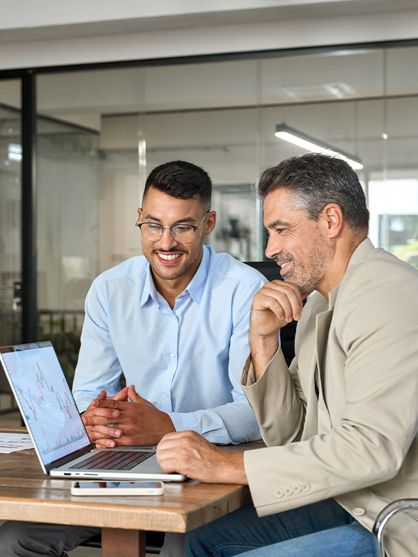 Two people smiling looking at laptop