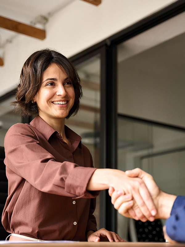business person smiling and shaking someones hand