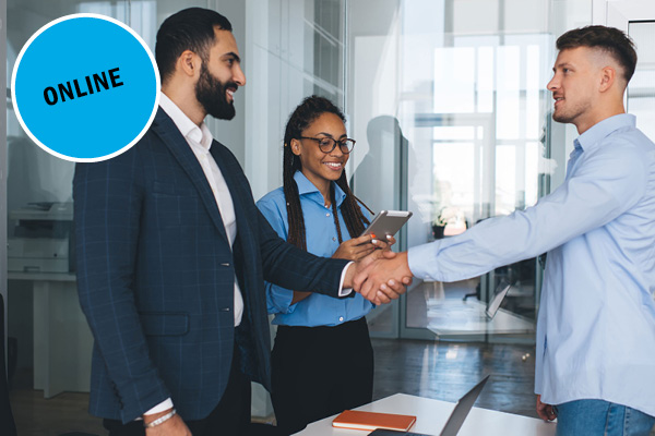 Two businessmen in an office shaking hands, smiling woman holding a tablet nearby