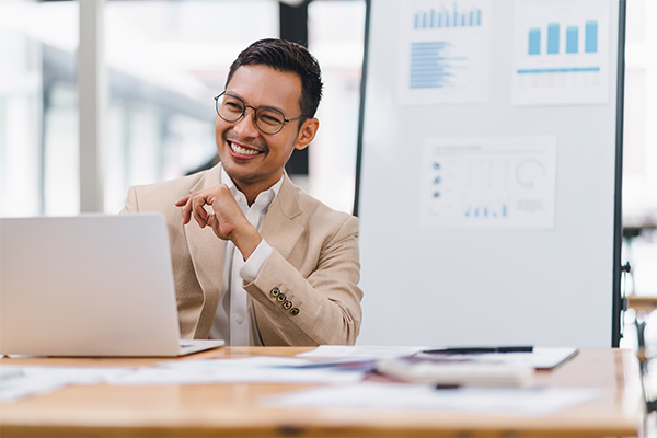 Person smiling in front of computer