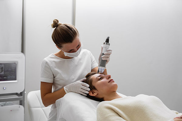 A woman receives a facial treatment in a spa.