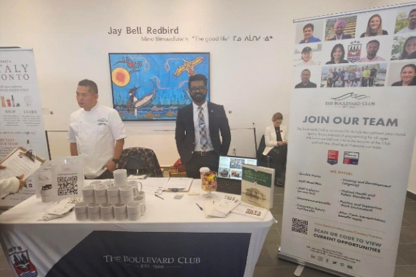 The Boulevard Club booth at event with two people Standing up