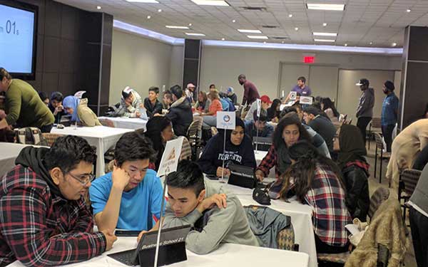 high school students at a table looking at a lap top