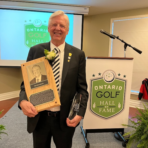 Bob Beauchemin smiling and holding the Ontario Golf Hall of Fame award