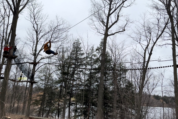 Tourism students using the zip line suspended above trees at Tree Top Trekking excursion in Brampton