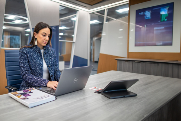 A young business woman sitting in a board room with her laptio