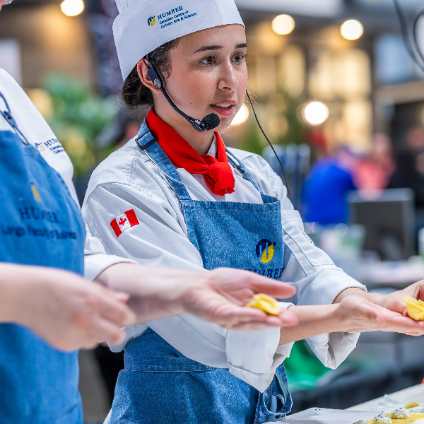 Humber NHS student performing a cooking demo with pasta