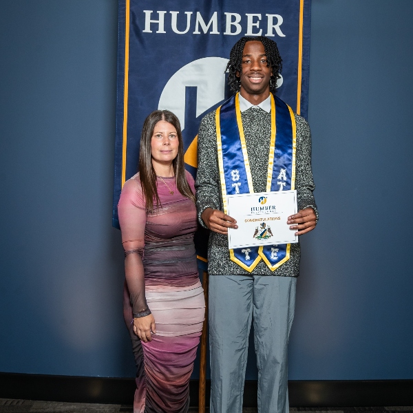 Nathan Waithe holding his diploma