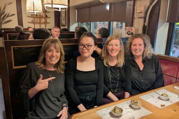 Hospitality - Hotel and Restaurant Operations Management alumni, Trang Pham sitting with Kristy Adams, Hospitality - Hotel and Restaurant Operations Management Program Co-ordinator in a booth at a restaurant 