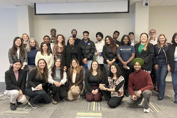 Event Alumni taking a group photo with current event students