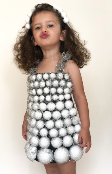 Child with styrofoam ball adorned dress