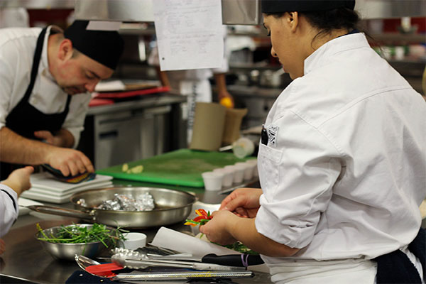 Two Humber culinary management students cooking food