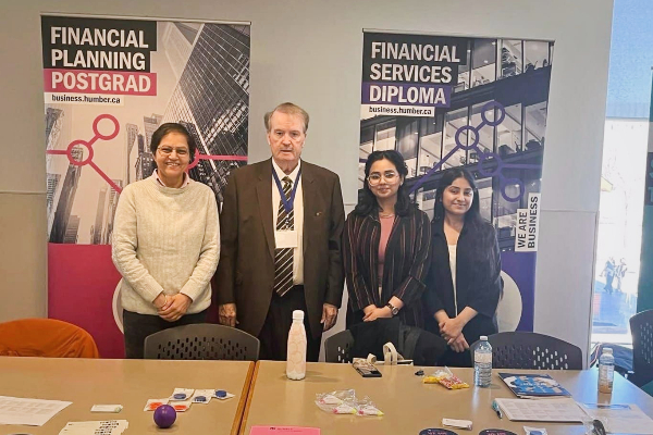 Financial Planning Professors and students smiling at a booth for Open House