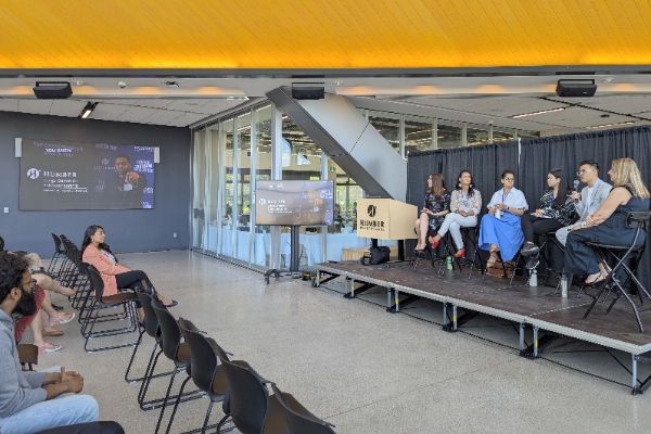 Speakers on a stage presenting to an audience