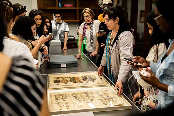 Fashion students looking at Fashion archival material