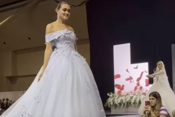 Woman modelling a white ball gown on a runway