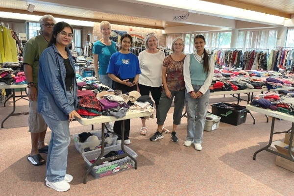 Fashion students organizing clothing at Eden United Church