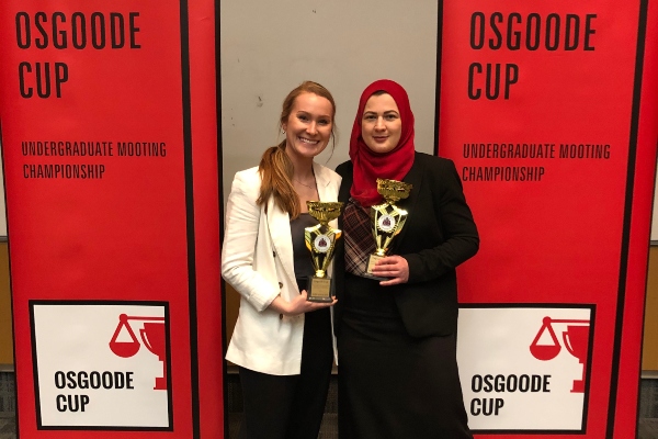 Students Elizabeth Hamilton and Elena Ferjani holding trophies at the 2020 Osgoode Cup National Undergraduate Mooting Competition