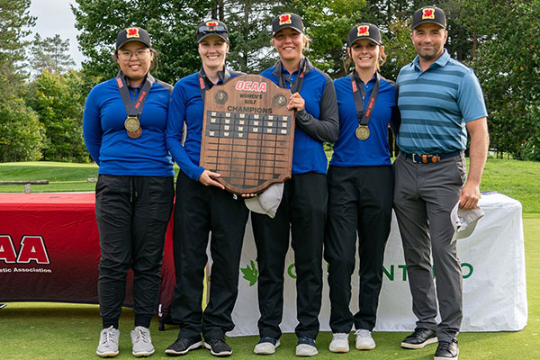 Women's golf team holding up the provincial championship plaque