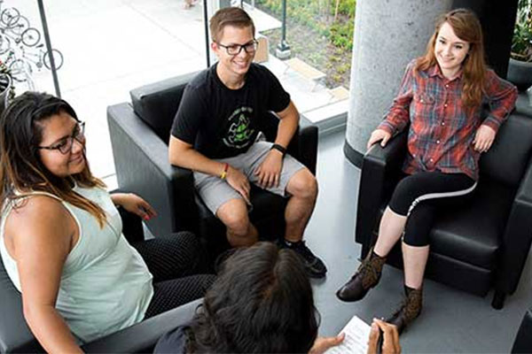 four people sitting in chairs talking