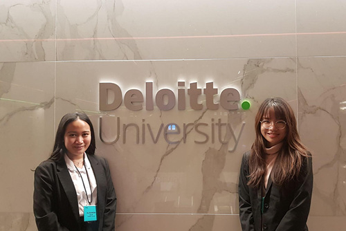 Humber students standing in front of Deloitte University signage at the event