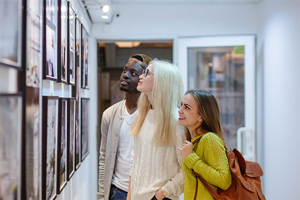 Three people looking at gallery
