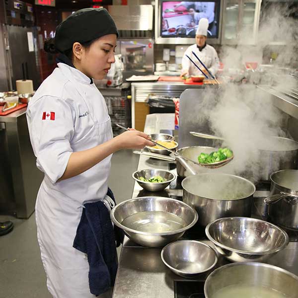 culinary student in front of stove