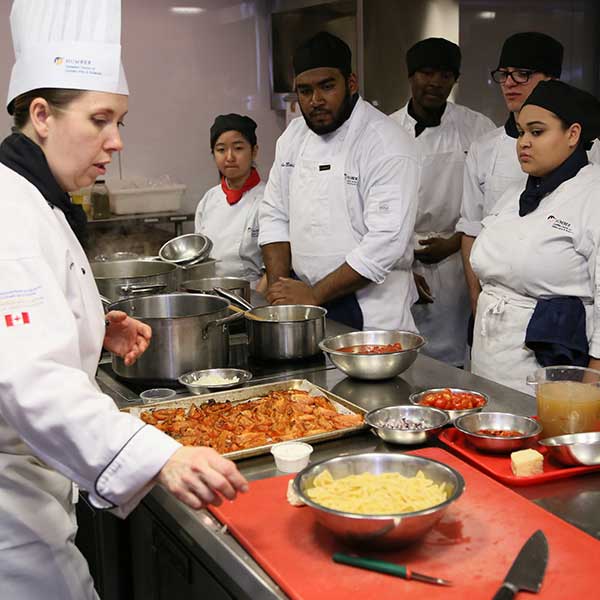 instructor demonstrating to culinary students