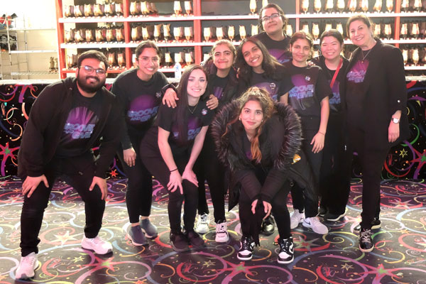 Group of students in roller rink smiling for photo