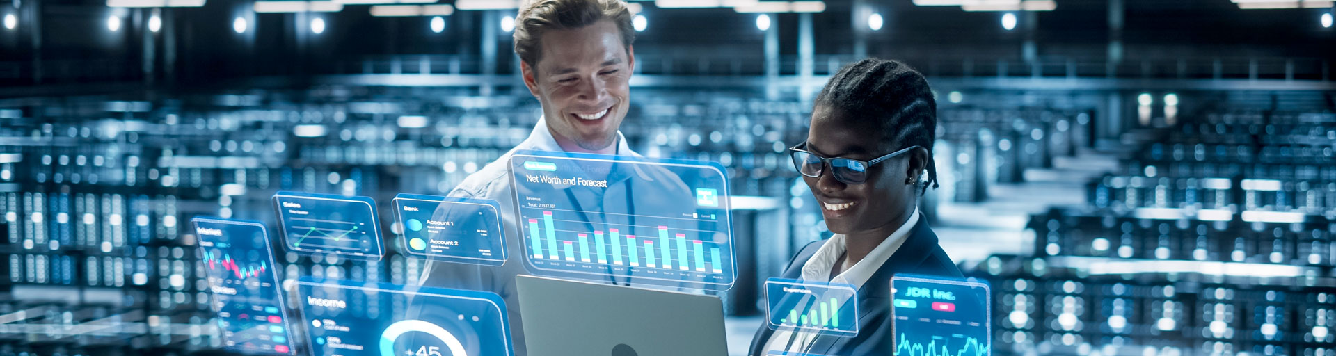 Two people looking at laptop with holographic graphs and charts around it