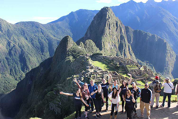 students posing for a photo by Machu Picchu