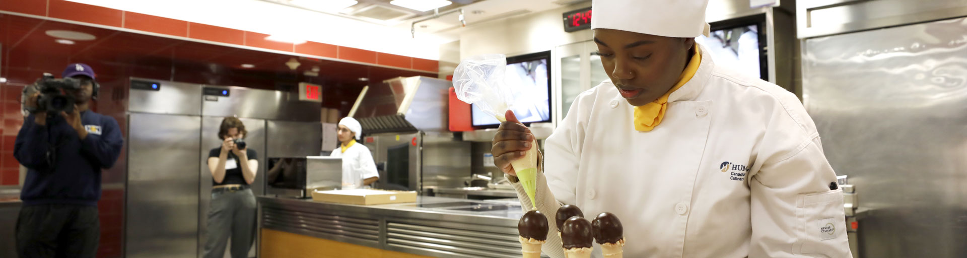 pastry student icing ice-cream cone cakes