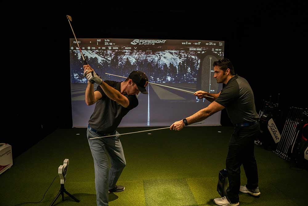student using golf simulator room