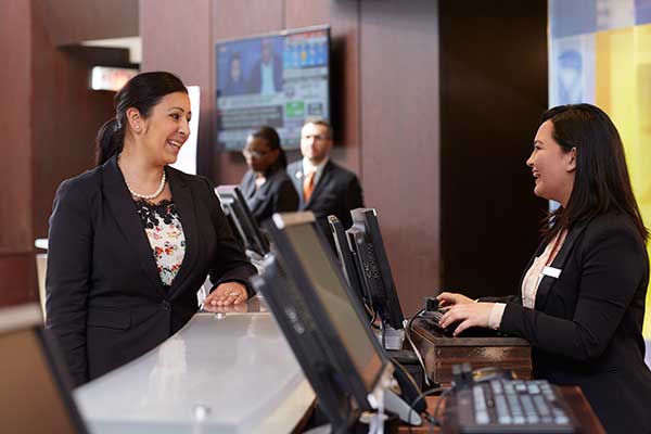 two people talking at reception desk