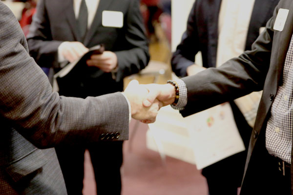 Two people in business suits shaking hands